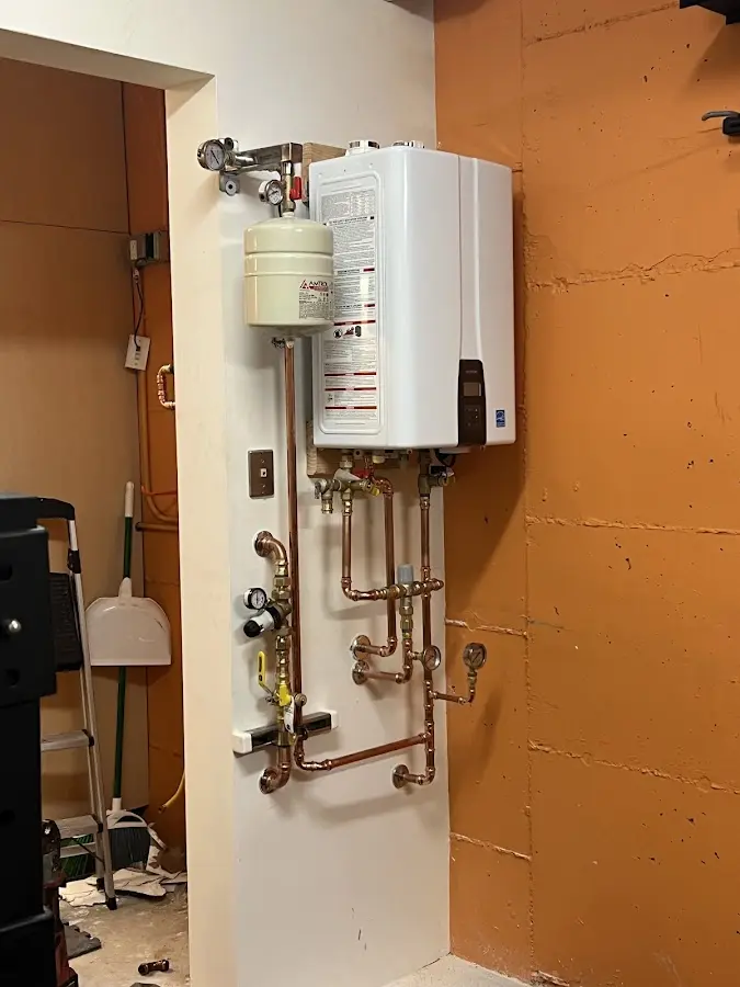 Plumbing technician inspecting water heater connections in Haleiwa